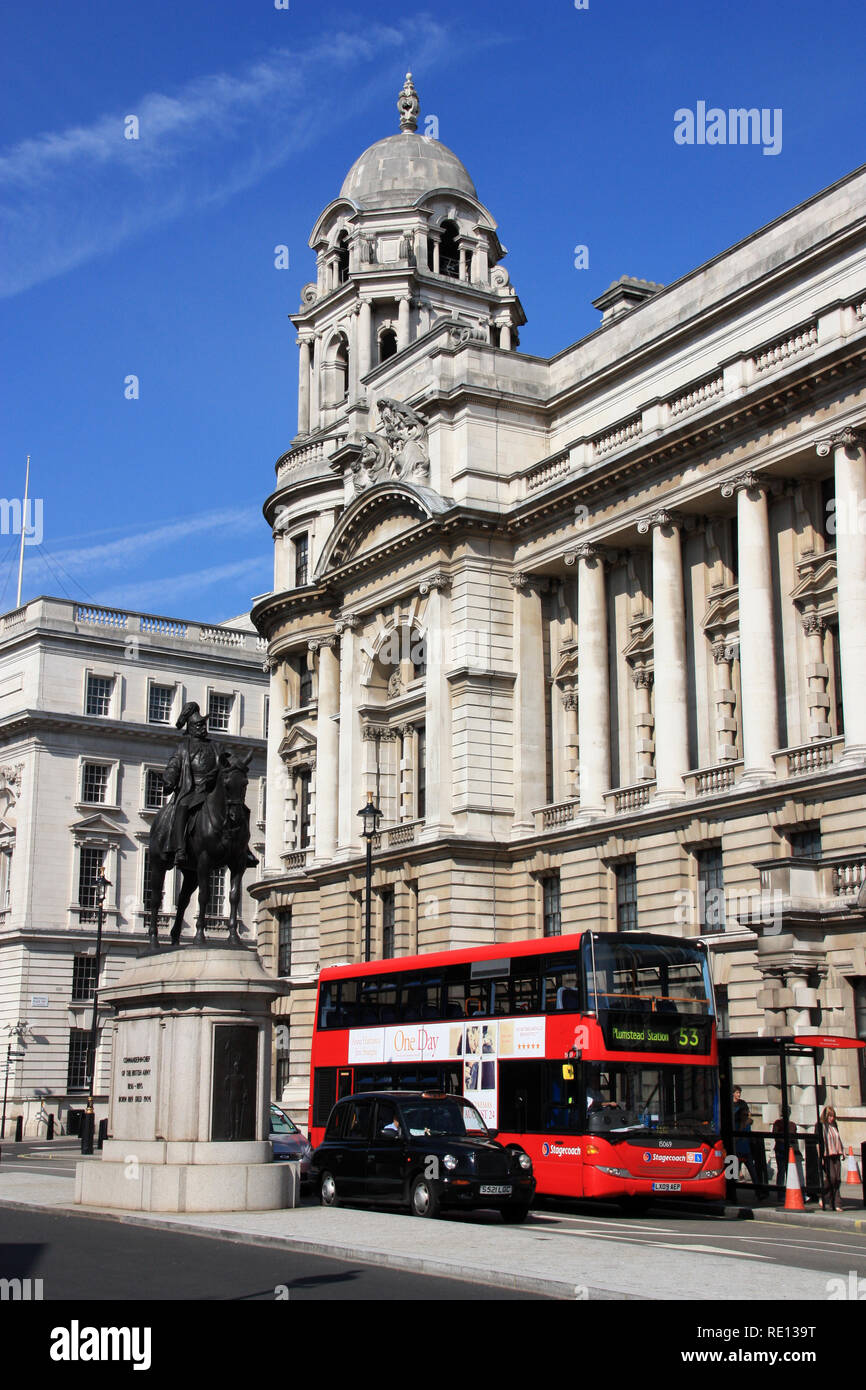 Statua equestre di Prince George, il Duca di Cambridge, un nero Londra Taxi di rosso e un autobus a due piani di fronte alla vecchia guerra Edificio per uffici Foto Stock