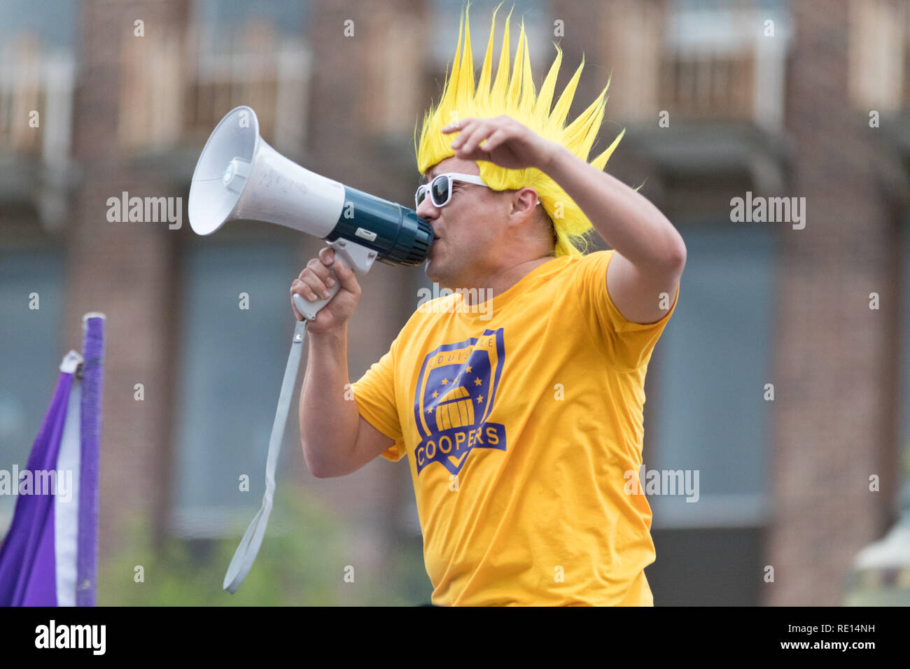 Louisville, Kentucky, Stati Uniti d'America - 03 Maggio 2018: il Pegasus Parade, membro della Louisville Coopers, utilizzando un altoparlante, con una parrucca gialla e sullaparte superiore di un Foto Stock