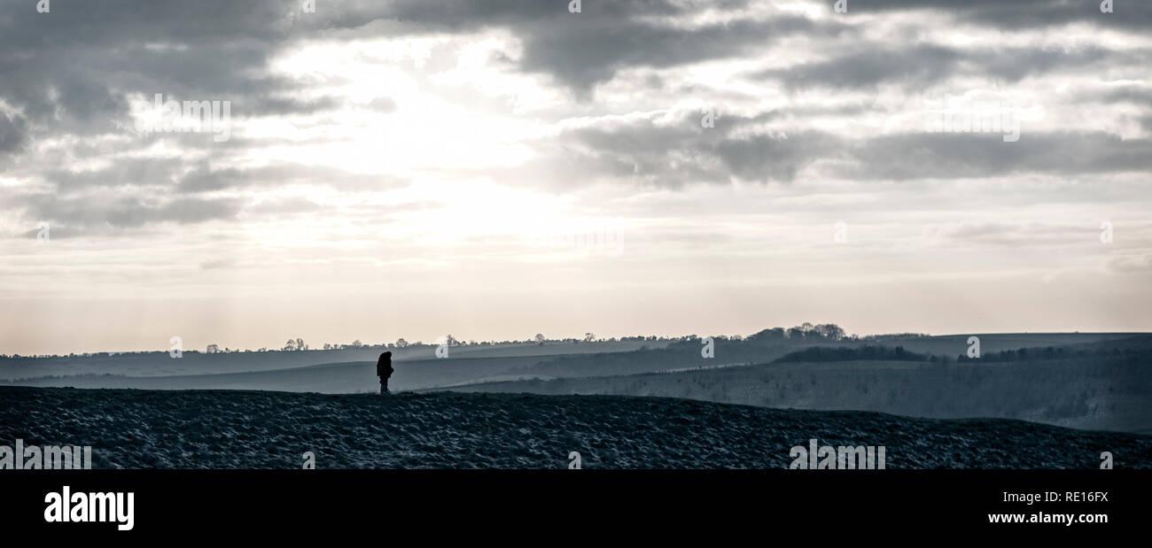 Escursionista solitario sul sentiero Ridgeway attraverso Barbury Castle, Swindon, Wiltshire, Regno Unito Foto Stock