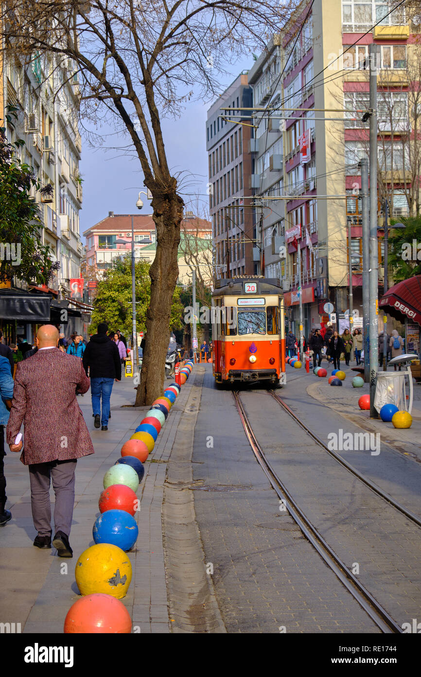 Il vecchio tram che passa attraverso le strade di Kadikoy sul lato Asiatico di Istanbul. Il quartiere alla moda è pieno di edifici colorati Foto Stock