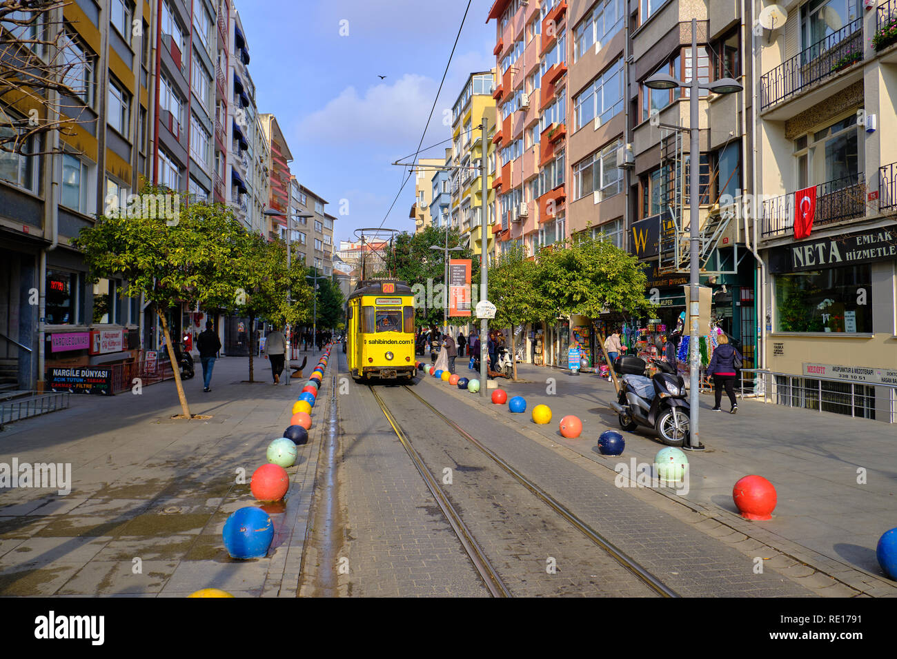 Il vecchio tram che passa attraverso le strade di Kadikoy sul lato Asiatico di Istanbul. Il quartiere alla moda è pieno di edifici colorati Foto Stock