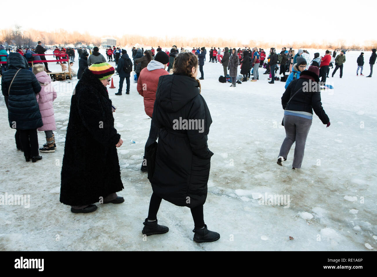 Donne ucraine di diversa età vestiti caldi in inverno i panni a piedi su ghiaccio e neve per prendere parte in inverno Cristo il battesimo dell'Acqua Nuoto tradizione. Foto Stock