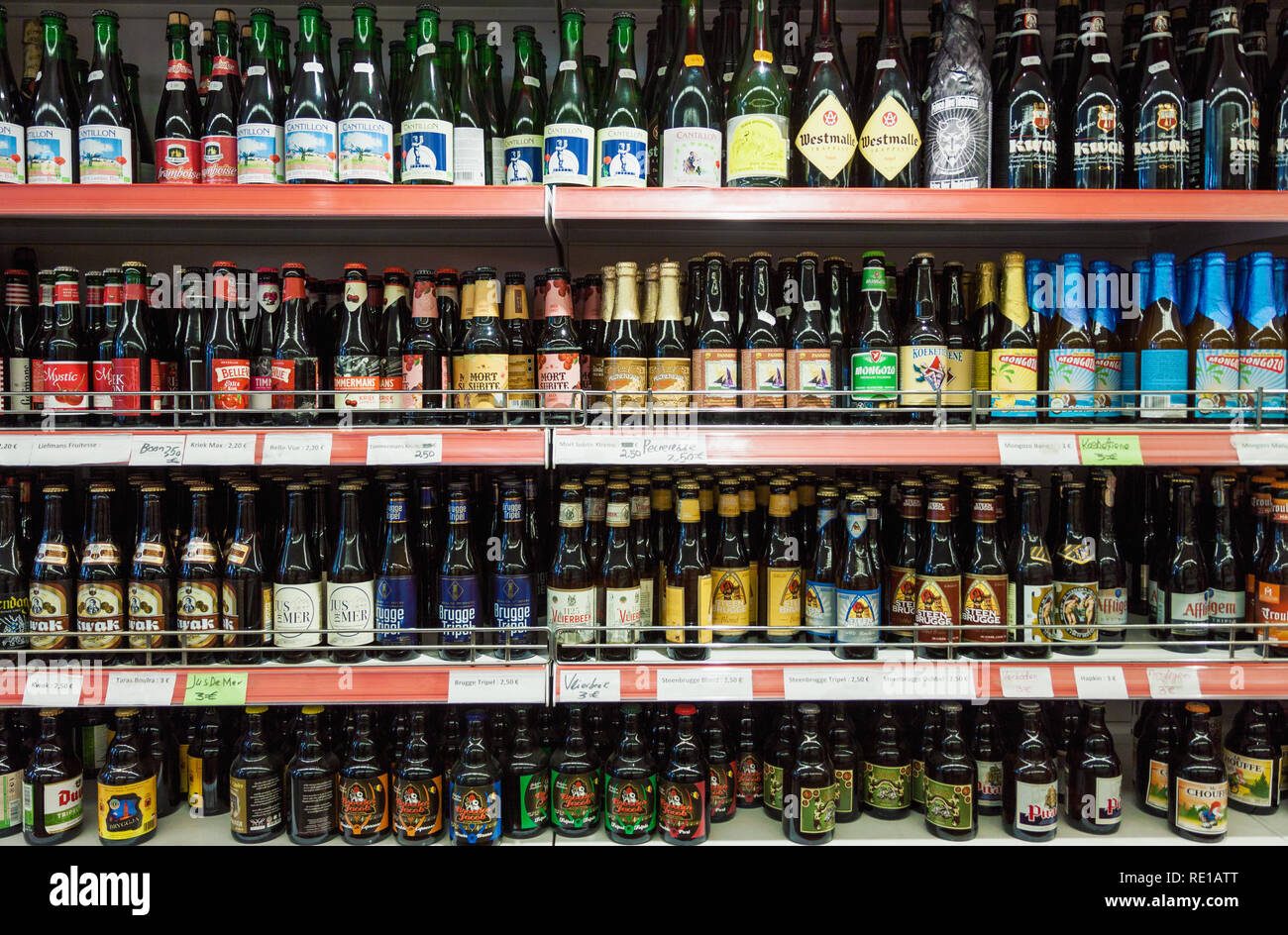 Varietà di belga birre artigianali per la vendita in un negozio di bottiglie di marca su shop espositore in un supermercato a Bruges Foto Stock