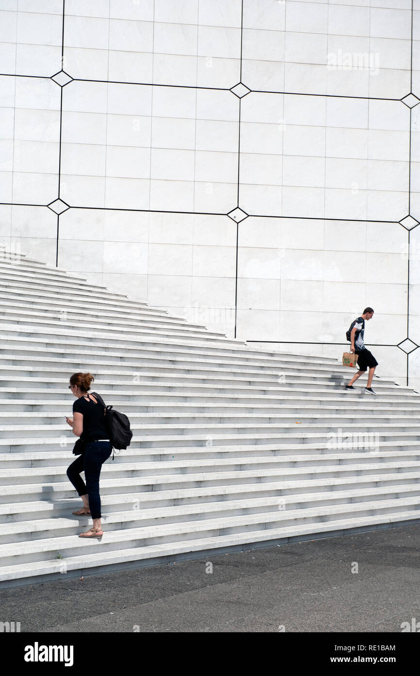 Una persona ascendente e discendente di un altro passi sotto La Grande Arche, La Defense, Parigi, Francia Foto Stock