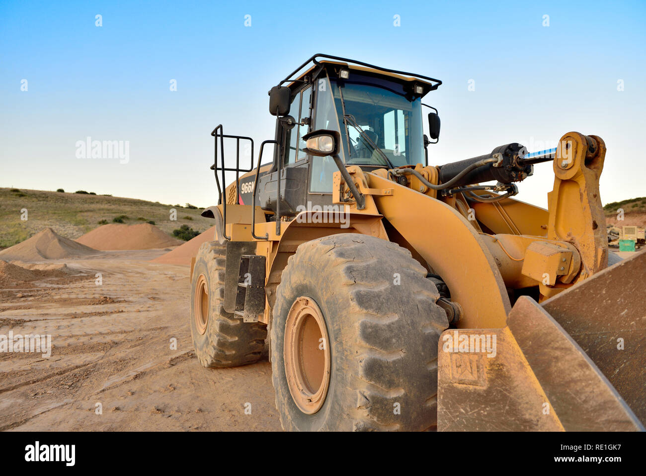 Giallo pesante il movimento terra Bulldozer al sito in costruzione con pali di sabbia in background Foto Stock