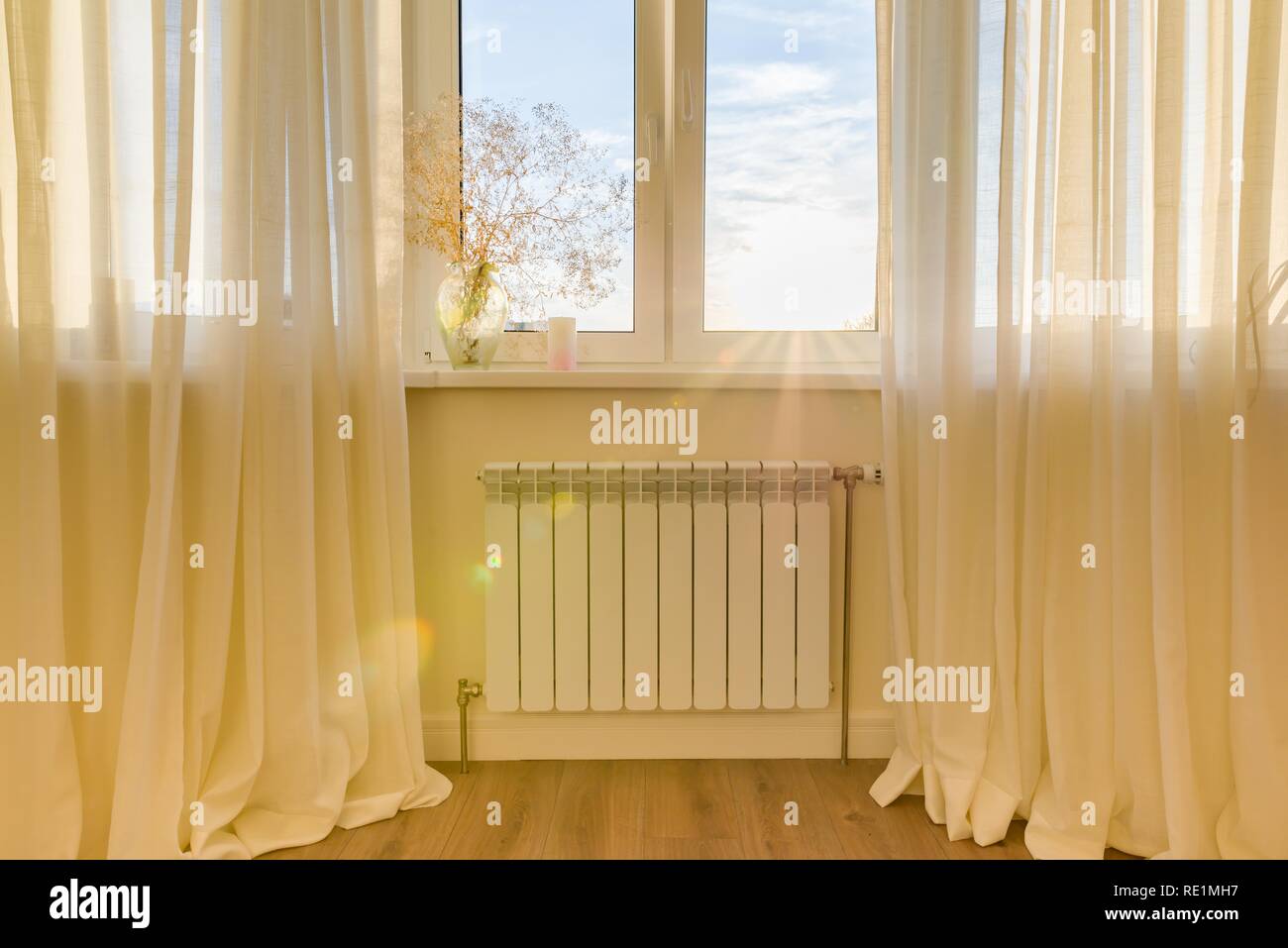 Radiatore bianco con termostato nell'appartamento. Riscaldante sotto la  finestra Foto stock - Alamy