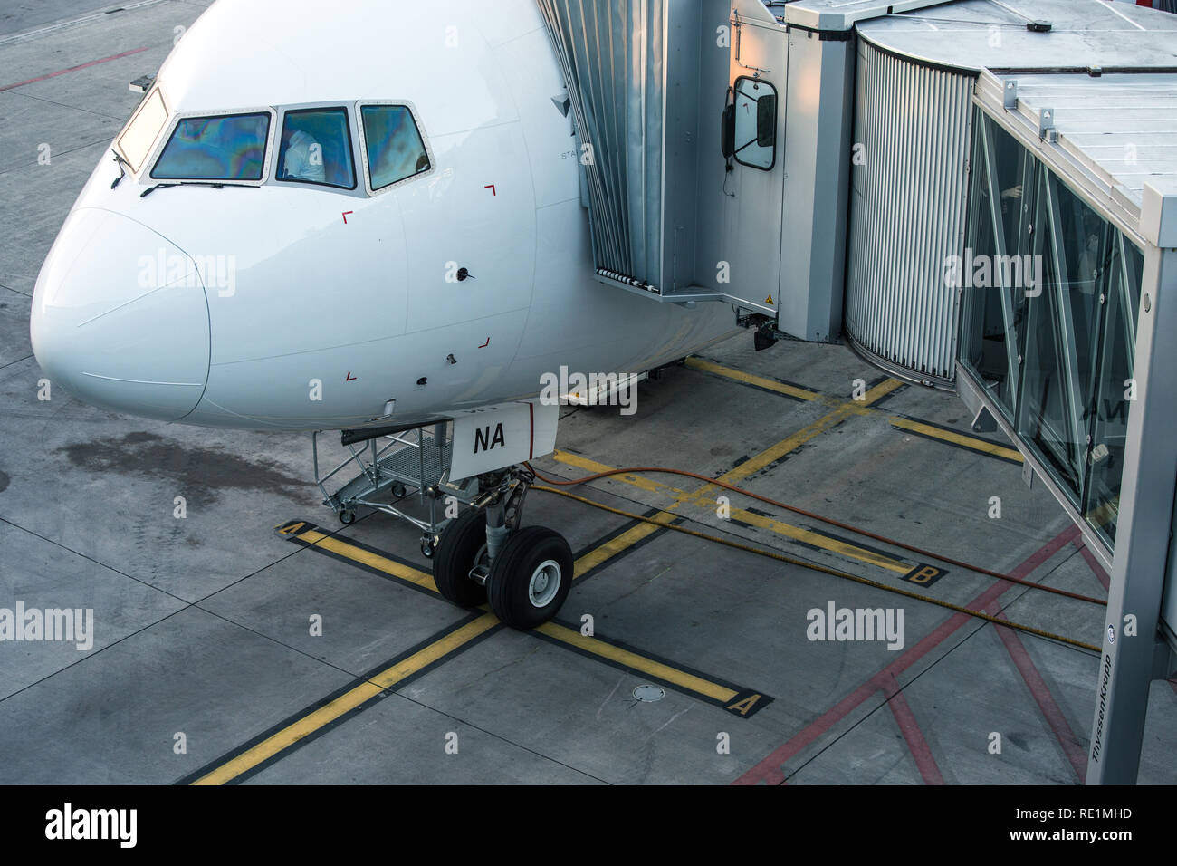 Aeromobili con corridoio di passaggio/tunnel essendo preparato per la partenza da un aeroporto internazionale - i passeggeri a bordo di un aereo in un aeroporto moderno Foto Stock