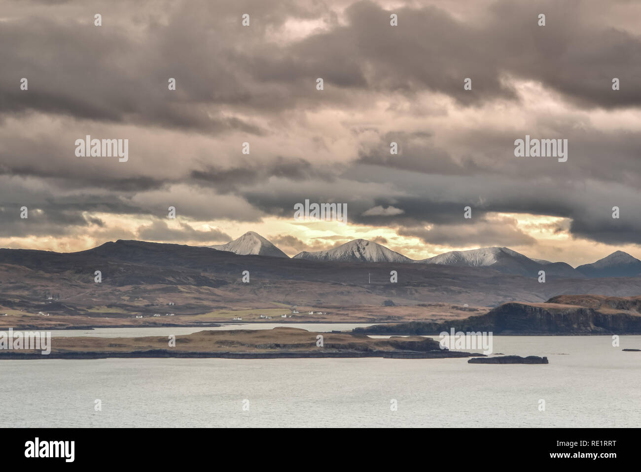 Isola di Skye in Scozia - Vista sul Cuillin Hills contemplati nel dicembre neve ed esposta alla luce del tramonto - cielo nuvoloso Foto Stock