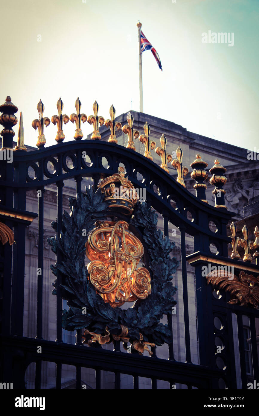 Cancello ornati a Buckingham Palace a Londra, Regno Unito, con l'Unione Jack in background Foto Stock