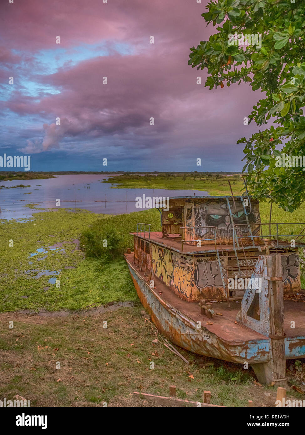 Iquitos, Perù- 28 Marzo 2018: il tramonto. Vista di una barca arrugginita, raibow e il fiume Itaya nel centro di Iquitos, Loreto, Perù. Amazon Foto Stock