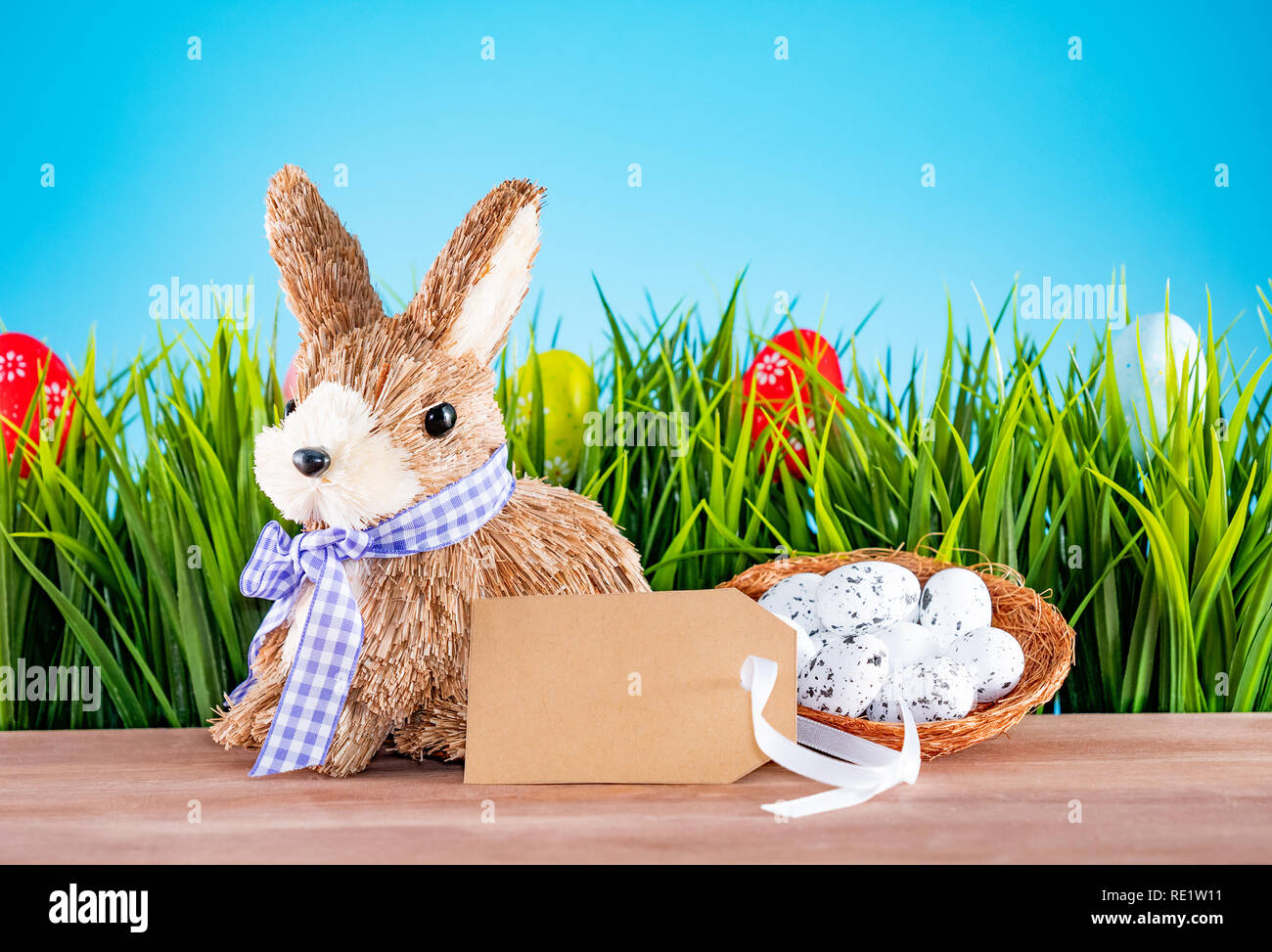 Uova di Pasqua e carino bunny sulla tavola di legno con erba verde. Decorazione di festa Foto Stock