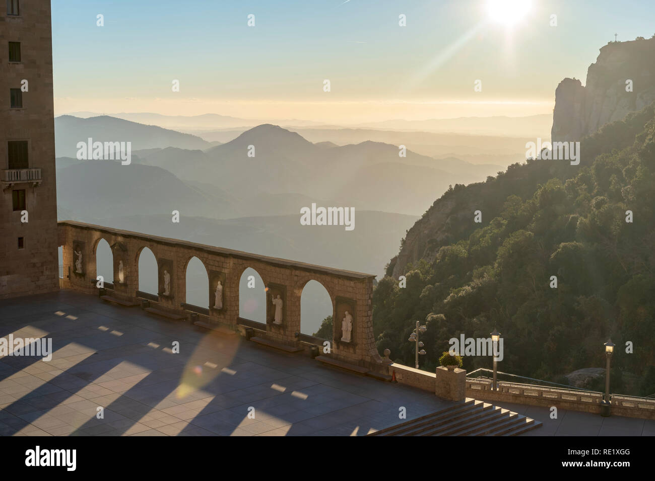 Viste dal monastero di Monserrat. Statue di pietra e gli archi all'esterno con le montagne sullo sfondo di mattina presto. Barcellona, Spagna. Foto Stock