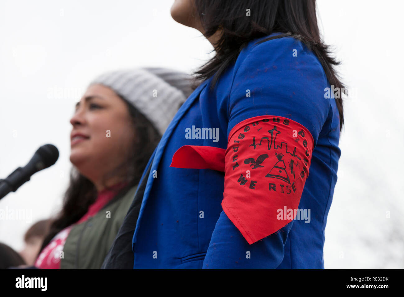 Washington, Stati Uniti d'America. 19 gen 2019. Monserrat Padilla, coordinatore presso il Washington immigrato Rete di Solidarietà e transgender avvocato, indossa una fascia da braccio a sostegno di tutti i popoli indigeni a pre-marzo rally per la Womxn del marzo 2019 di Seattle. Parlando è Colleen Echohawk, membro della band Kithehaki della nazione Pawnee. Sabato di marzo e Rally, organizzato da Seattle Womxn marciare in avanti in collaborazione con MLK giorno gli organizzatori, sarà seguita domenica da una giornata di azione e lunedì MLK eventi della durata di un giorno in onore di Martin Luther King Jr. Domenica Womxn agiscono su Seattle è un giorno di cittadine di Foto Stock