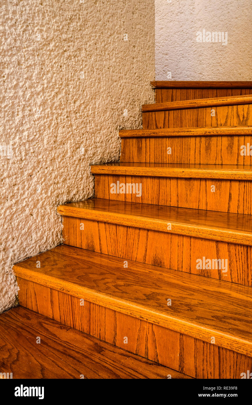 Un avvolgimento scala in legno tra pareti bianche all'interno di una casa Foto Stock