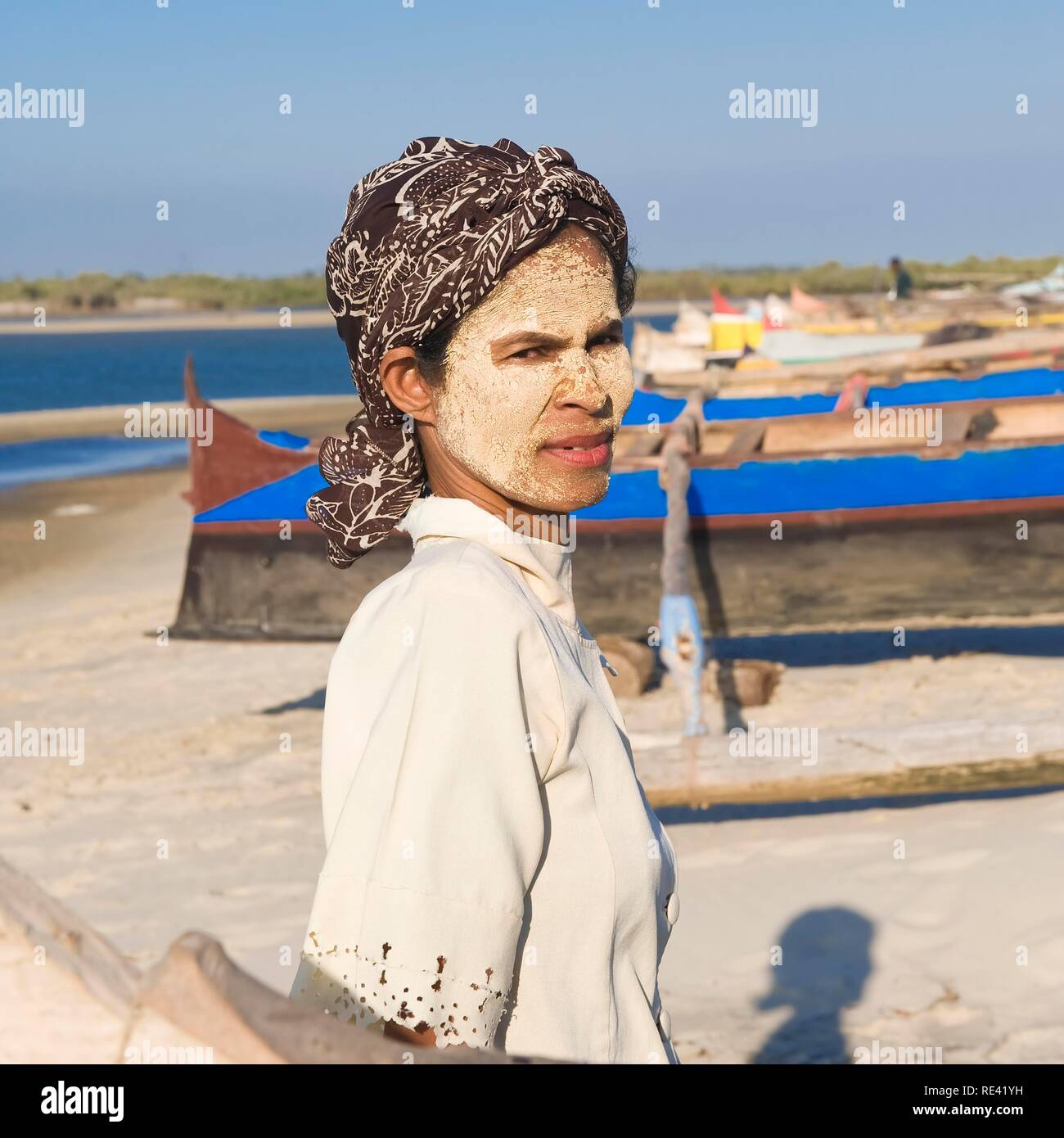 Donna faccia con protezione contro il sole sul suo viso vicino a un villaggio di pescatori, Morondava, Madagascar, Africa Foto Stock