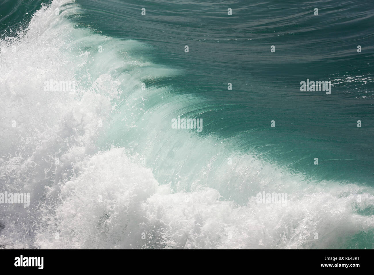 Wave si trasforma da verde intenso a bianco mentre si schianta sulla spiaggia di Porthleven Foto Stock