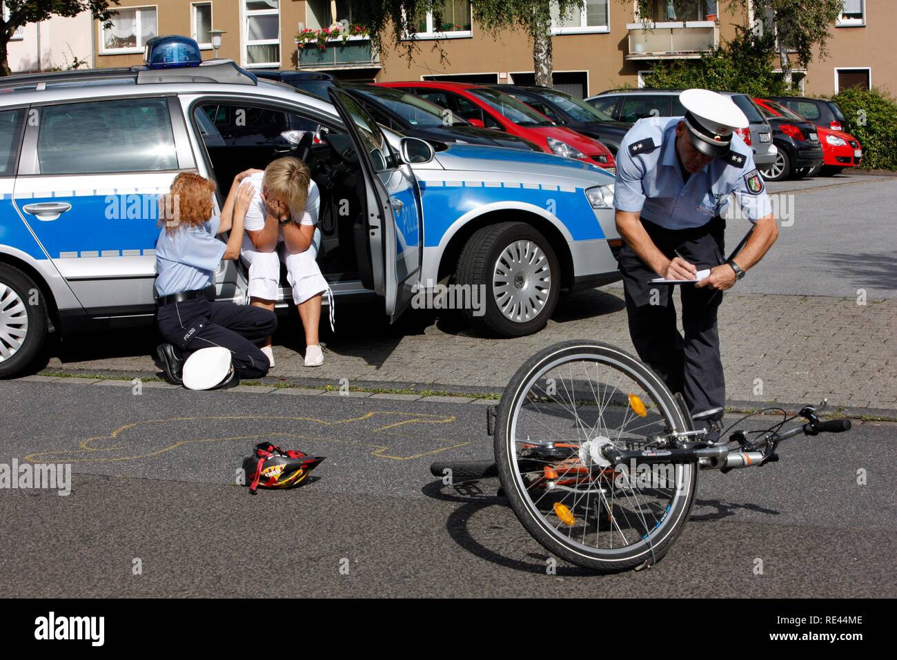 Gli ufficiali di polizia assistere alla testimonianza di un incidente in bicicletta, assistenza alle vittime e la consulenza di emergenza, rievocazione Foto Stock