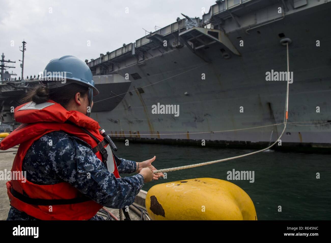 OKOSUKA, Giappone (nov. 21, 2016) marinaio Marshawanda Fuller, da McLemoresville, Tennessee, heaves una linea di ormeggio come la marina è solo distribuita portaerei USS Ronald Reagan (CVN 76), restituisce al comandante le attività della flotta Yokosuka (CFAY) dopo una pattuglia di routine. Ronald Reagan, ammiraglia del Carrier Strike gruppo cinque (CSG 5), viene distribuito a Yokosuka, Giappone, a sostegno della sicurezza e della stabilità della Indo-Asia-regione del Pacifico. Foto Stock