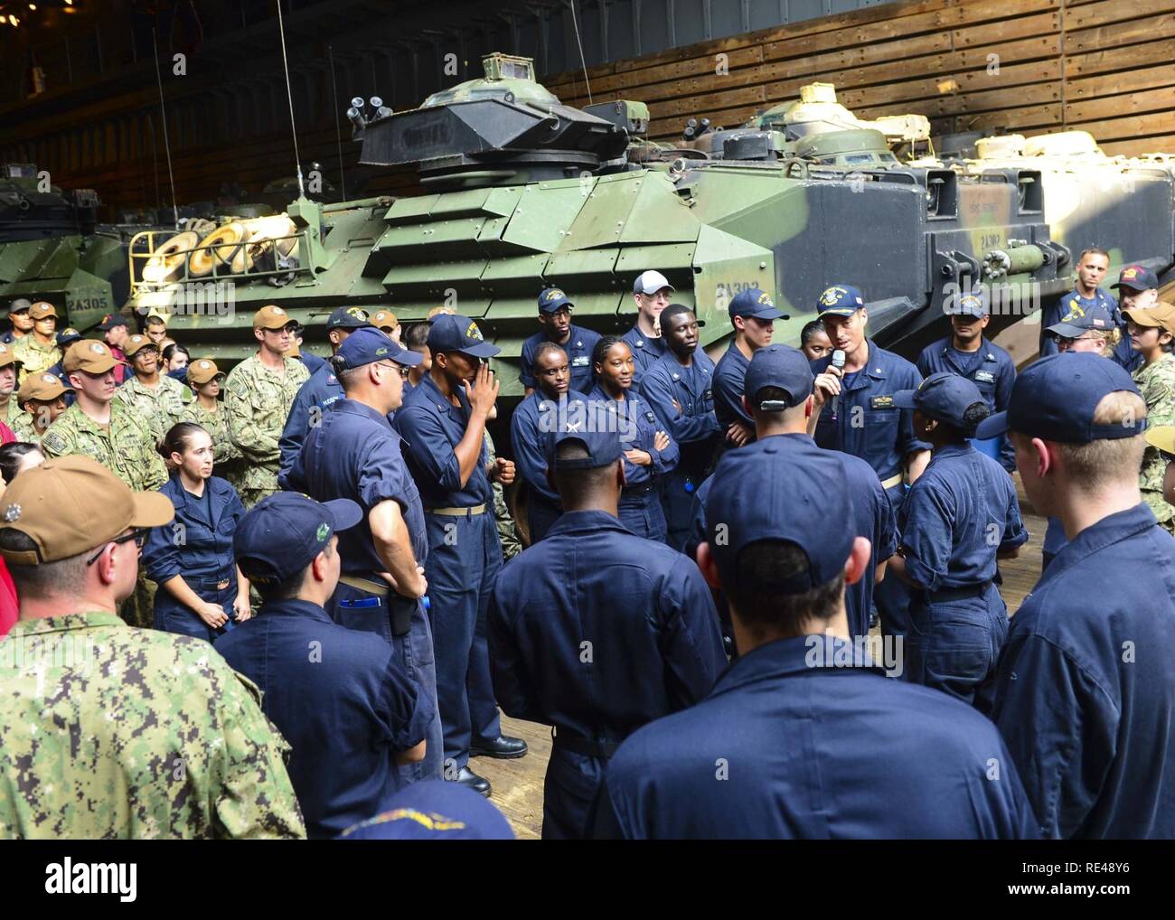 Stati Uniti 5TH FLOTTA AREA DI OPERAZIONI (nov. 23, 2016) della Cmdr. Ethan Regola, comandante della dock anfibio sbarco nave USS Whidbey Island (LSD 41), affronta l'equipaggio nel pozzetto deck dopo un frocking una cerimonia. Whidbey Island viene distribuito con la Vespa Anfibia gruppo pronto per supportare le operazioni di sicurezza marittima e di teatro la cooperazione in materia di sicurezza gli sforzi negli Stati Uniti Quinta Flotta area di operazioni. Foto Stock