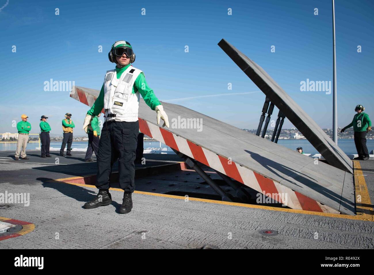 SAN DIEGO (nov. 23, 2016)- marinai Wilton Rosado controlla la sicurezza mentre si abbassa il getto di blast deflettore durante un quartieri generali di esercizio a bordo della portaerei USS Theodore Roosevelt CVN (71). Theodore Roosevelt è attualmente ormeggiate e homeported in San Diego subendo una pianificata la manutenzione pianificata la disponibilità. Foto Stock