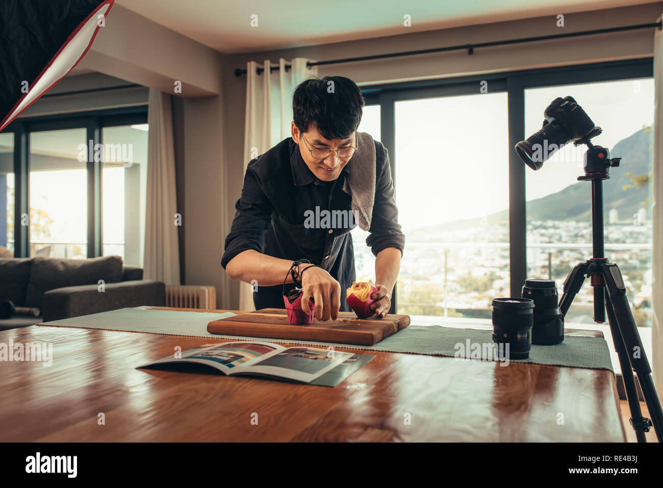 Cibo fotografo blogger facendo preparazione di cibo sul tavolo. Fotografo di alimentare lo styling cibo nel suo studio per un video blog. Foto Stock