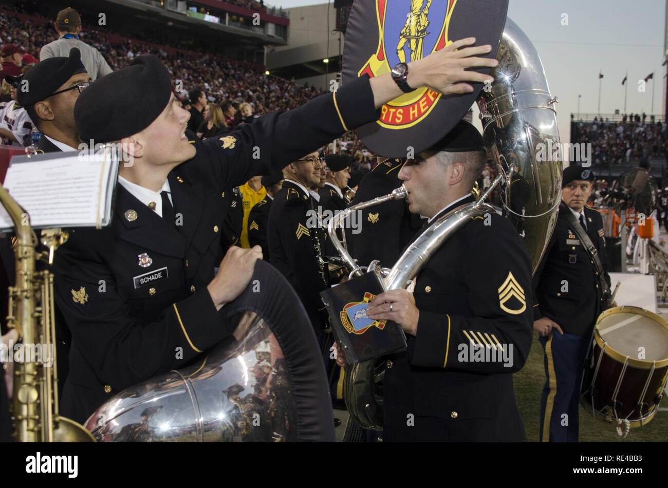 Spc. Lancia Schade, un bandsman con la 282Army Band fuori di Fort Jackson, aiuta a regolare il quadro di un altro membro della band prima di andare sul campo durante il tempo di emisaturazione feste come l'Università della Carolina del Sud militare di apprezzamento giorno gioco, nov. 19 A Williams-Brice Stadium in Columbia, S.C. Foto Stock