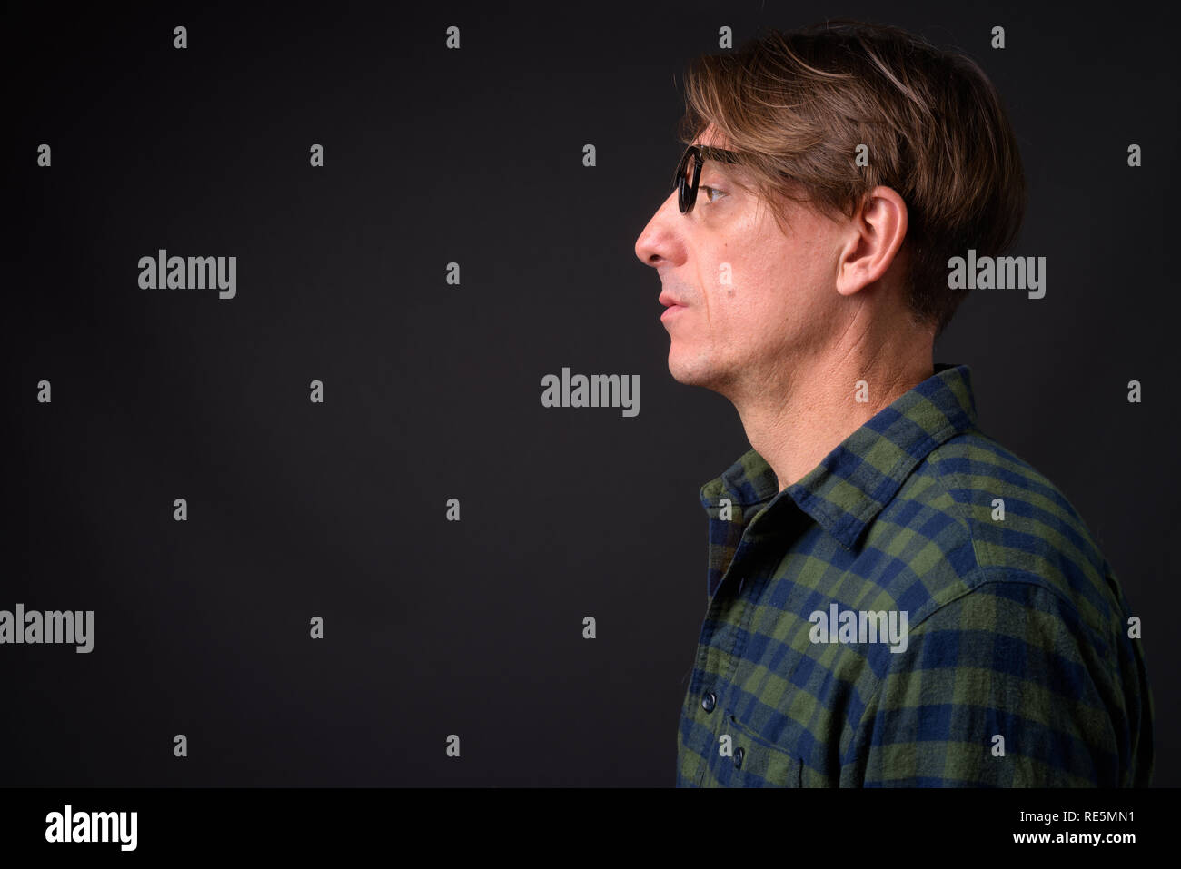 Vista di profilo di coppia bello italiano uomo contro uno sfondo grigio Foto Stock