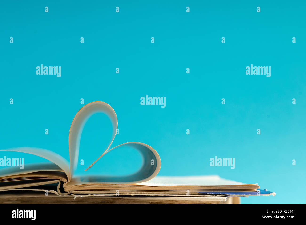Vecchio hard cover pagina di libro decorare a forma di cuore per amore nel giorno di San Valentino con sfondo sfocato e stile vintage. Composizione di amore, di apprendimento, s Foto Stock