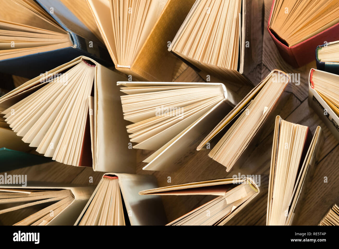 Vecchio e usato hardback libri, libri di testo visto da sopra il pavimento in legno. Libri e lettura sono essenziali per il miglioramento di auto, acquisendo conoscenze e s Foto Stock