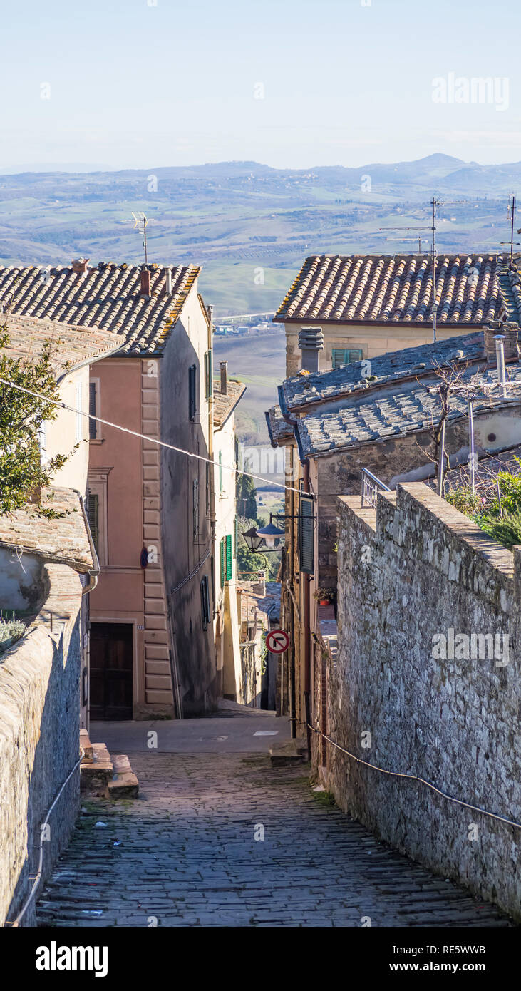 Vista sulle colline intorno alla città di Montalcino da una ferita tra le case Foto Stock