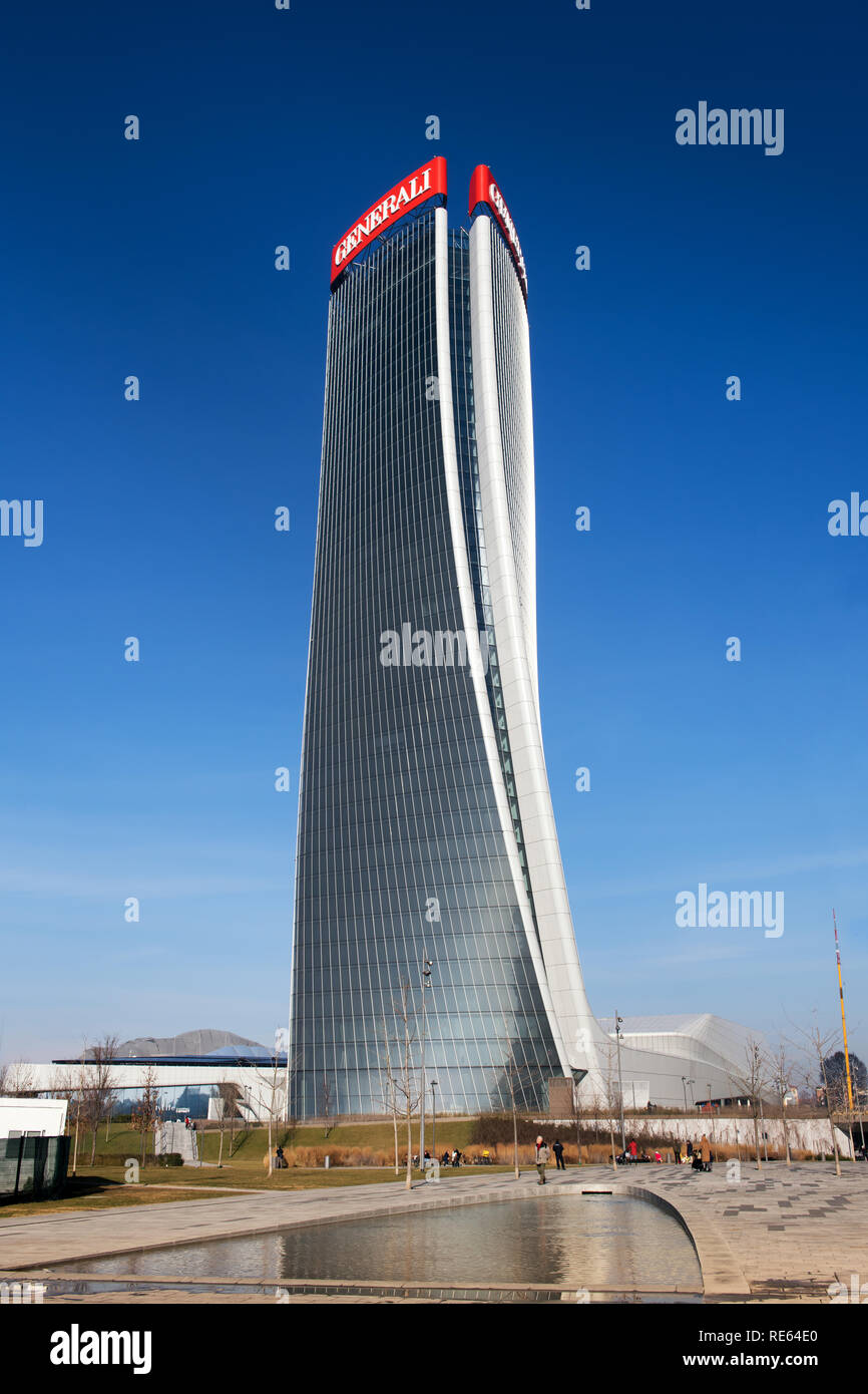 Vista esterna della torre Generali di Milano con il suo caratteristico design deformato dall'architetto Zaha Hadid si riflette in una piscina sottostante contro un cielo blu Foto Stock