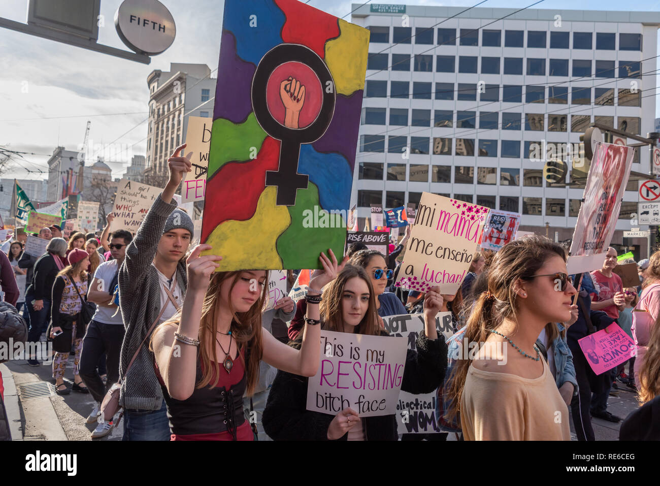 San Francisco, Stati Uniti d'America. 19 gennaio, 2019. Le giovani donne tra i manifestanti di donne del marzo a San Francisco. Di cui uno detiene una lettura del segno "Questa è la mia cagna resistente volto", mentre l'altra contiene un segno colorato del simbolo femminile con un pugno. Credito: Shelly Rivoli/Alamy Live News Foto Stock