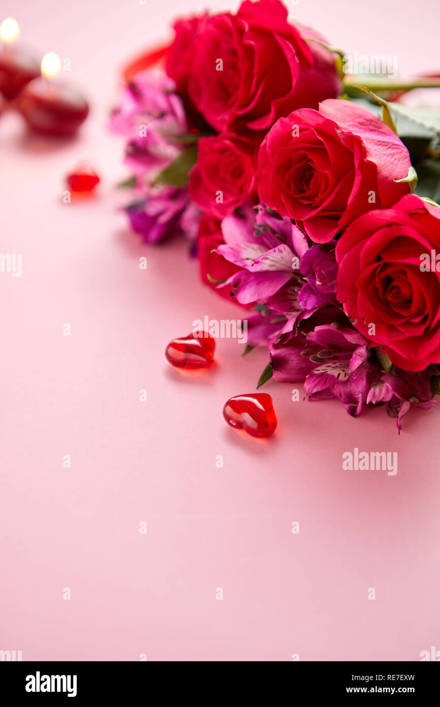 Romantico Sfondo San Valentino. Candele accese e cuori rossi decorati con  fiori bianchi Foto stock - Alamy