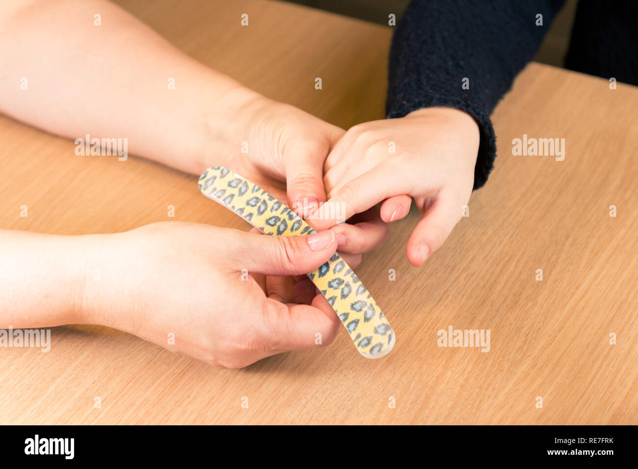 Il deposito di chiodi di giovane ragazza alla cucina tavola, close up delle mani - orizzontale Foto Stock