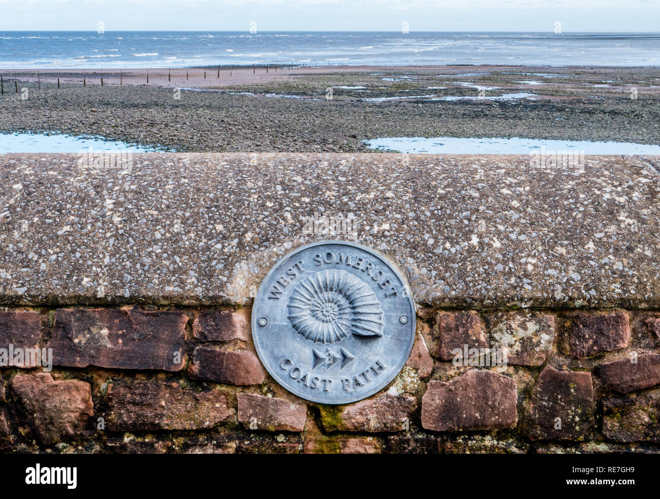 Portare la placca waymarker vicino all'inizio del Somerset West coast path Minehead che costeggia la contea di Jurassic Coast e ha l'Ammonita come suo emblema Foto Stock