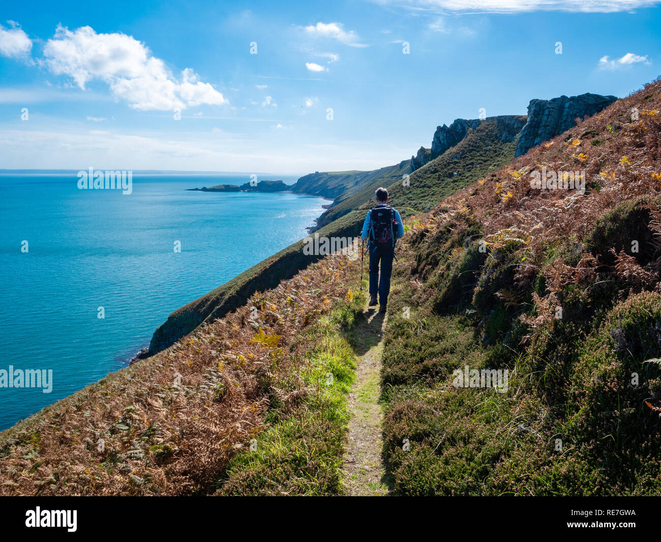 Il camminatore femmina su un percorso lungo la pendenza ripida costa est di Lundy Island nel canale di Bristol al largo della costa del North Devon Regno Unito Foto Stock
