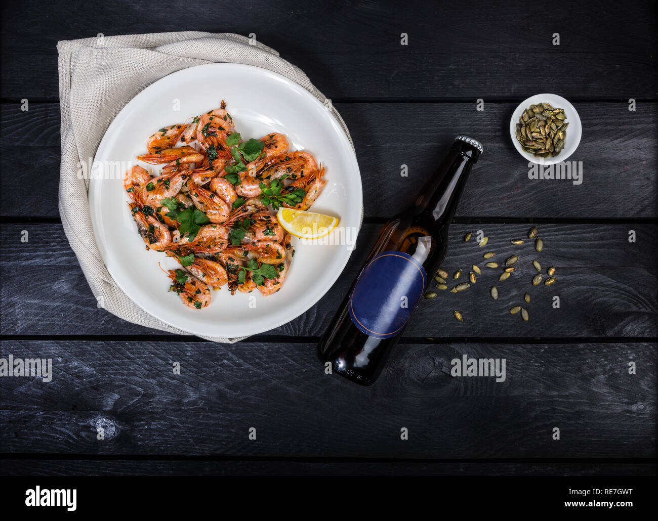 Gamberi fritti con prezzemolo e aglio con bottiglia Foto Stock