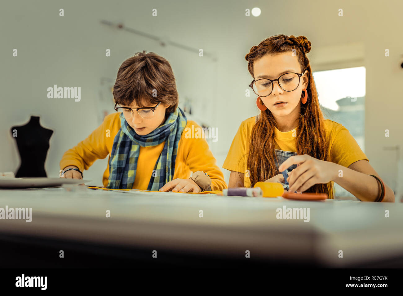 I bambini che frequentano la scuola di design utilizzando i fili colorati Foto Stock