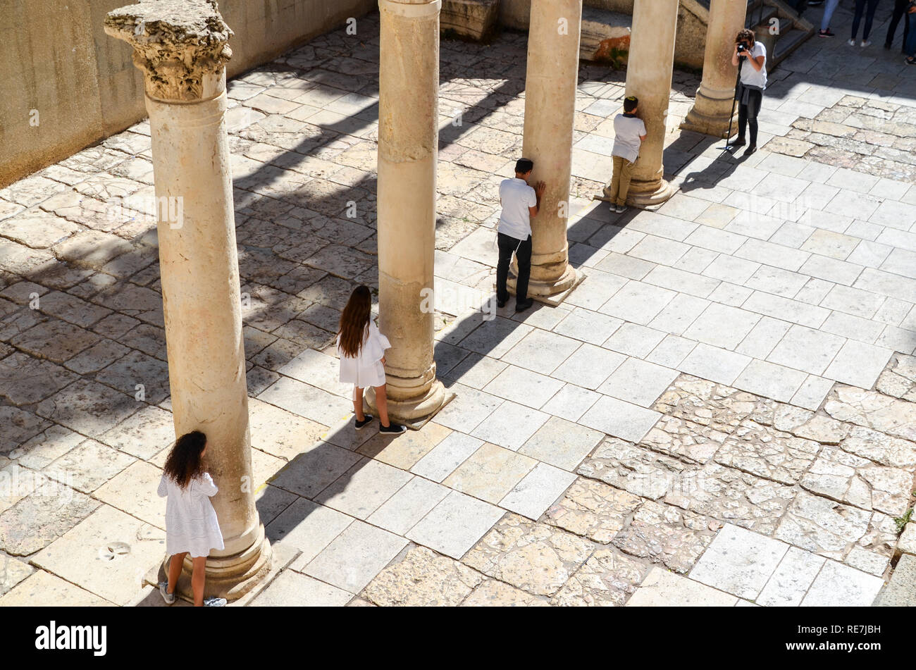 Giovane famiglia ebraica di scattare le foto tra pilastri in ambito romano della città vecchia di Gerusalemme Foto Stock
