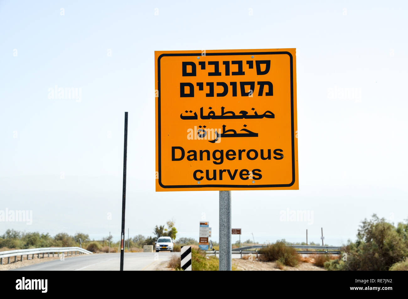 Cartello stradale "pericoloso curve", in ebraico, in arabo e in inglese, in Cisgiordania Palestina/Israele Foto Stock