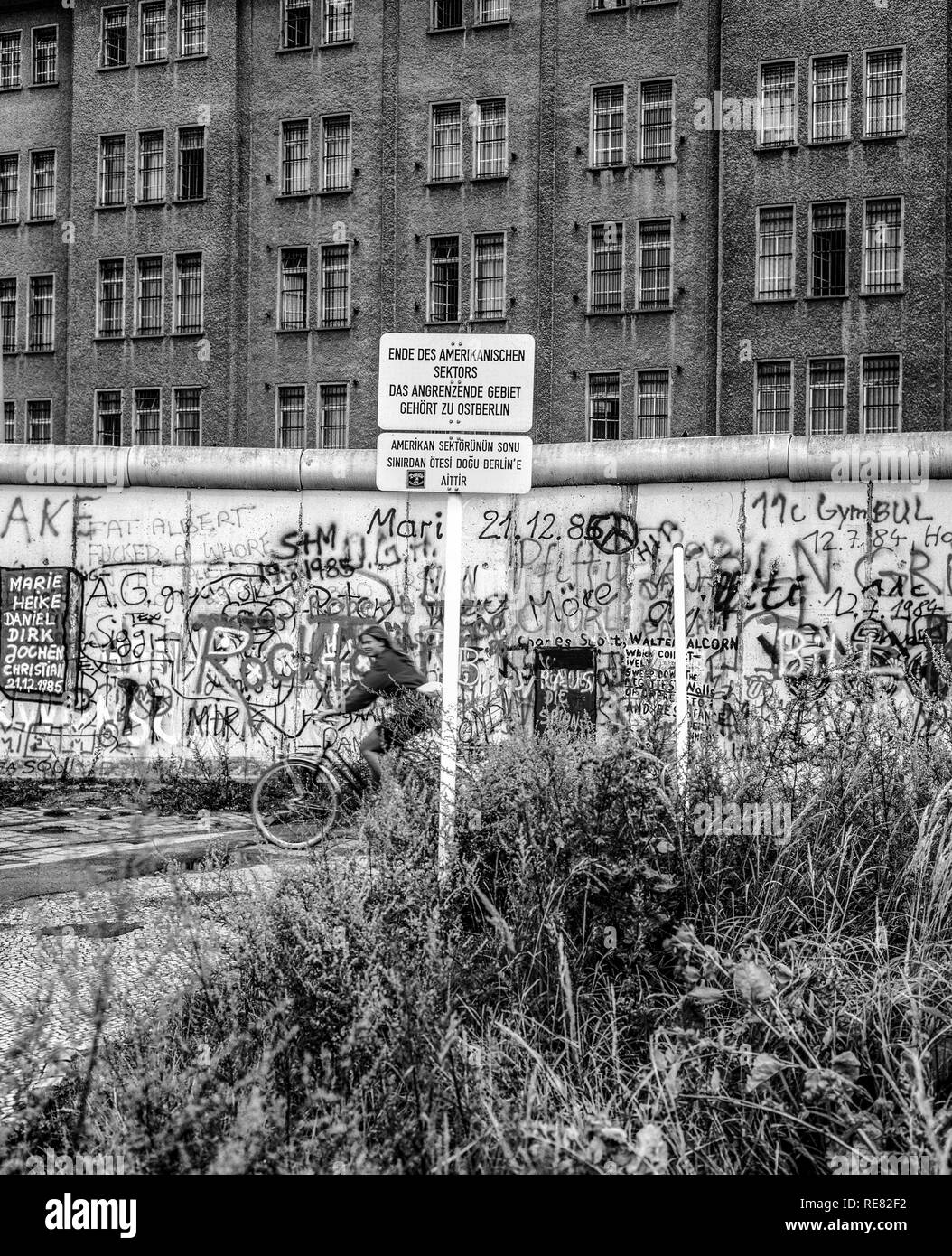 Agosto 1986, muro di Berlino graffitis, cartello di avviso per la fine del settore americano, ciclista, Berlino Est edificio, Berlino Ovest lato, Germania, Europa Foto Stock
