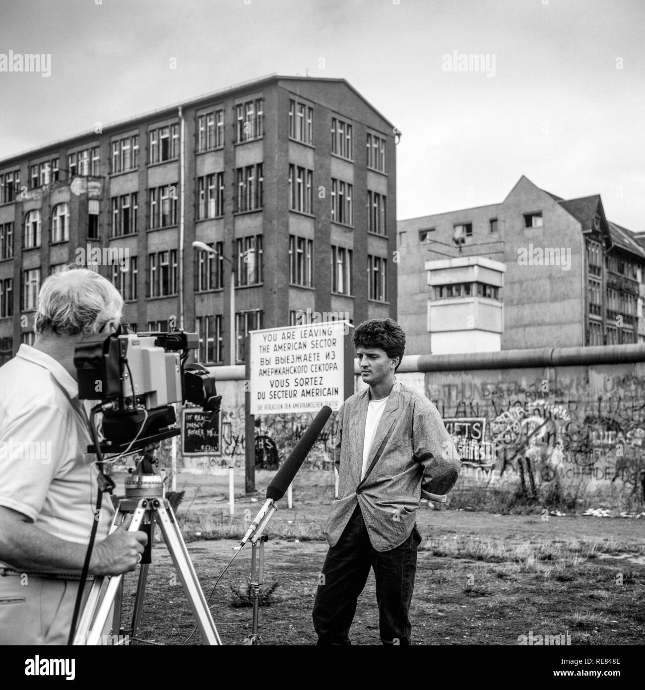 Agosto 1986, TV intervista di un ex soldato Est, muro di Berlino graffitis, Berlino Est torre di avvistamento, Zimmerstrasse street, Berlino Ovest, Germania, Europa Foto Stock