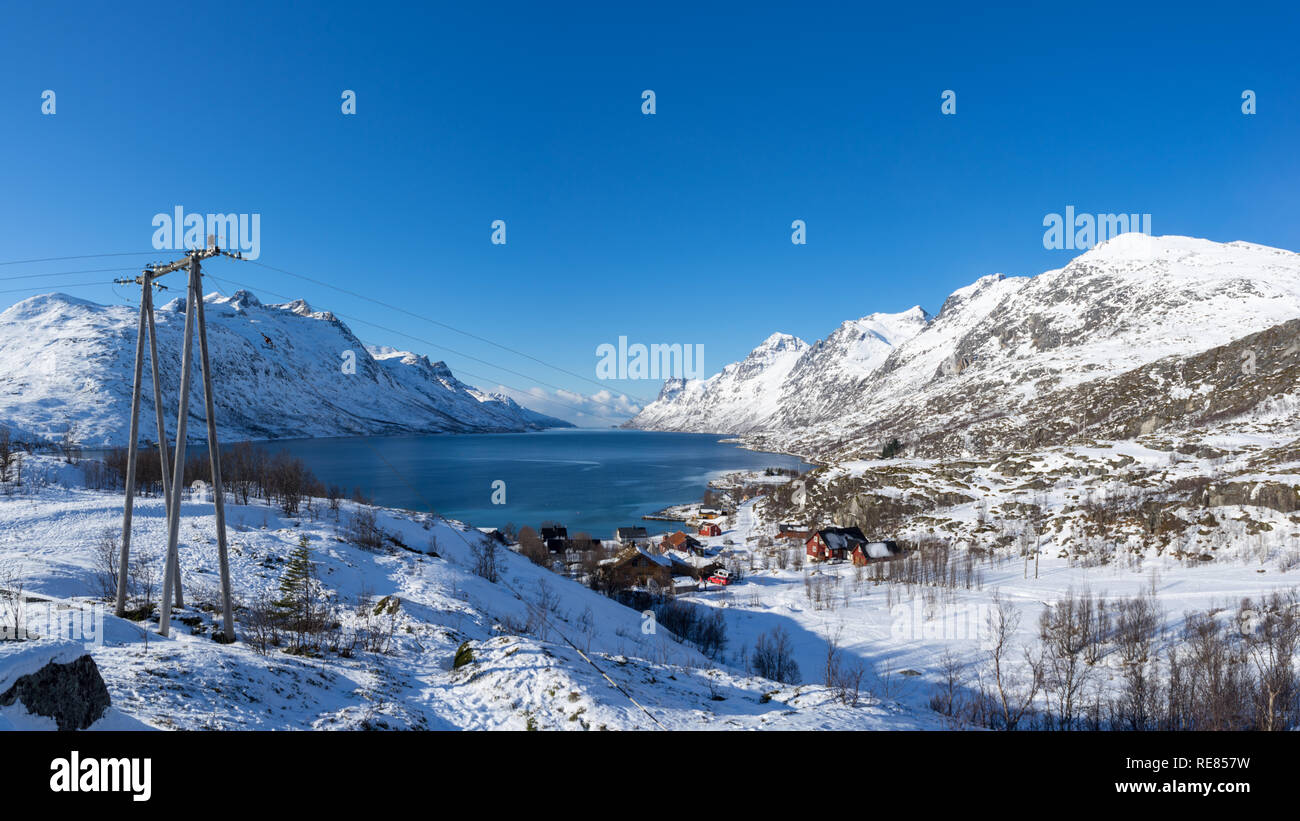 Inverno pieno di sole vista diurna su Erstfjordbotn, Kvaloya, Tromso, Norvegia con il fiordo, mare, montagna e neve Foto Stock