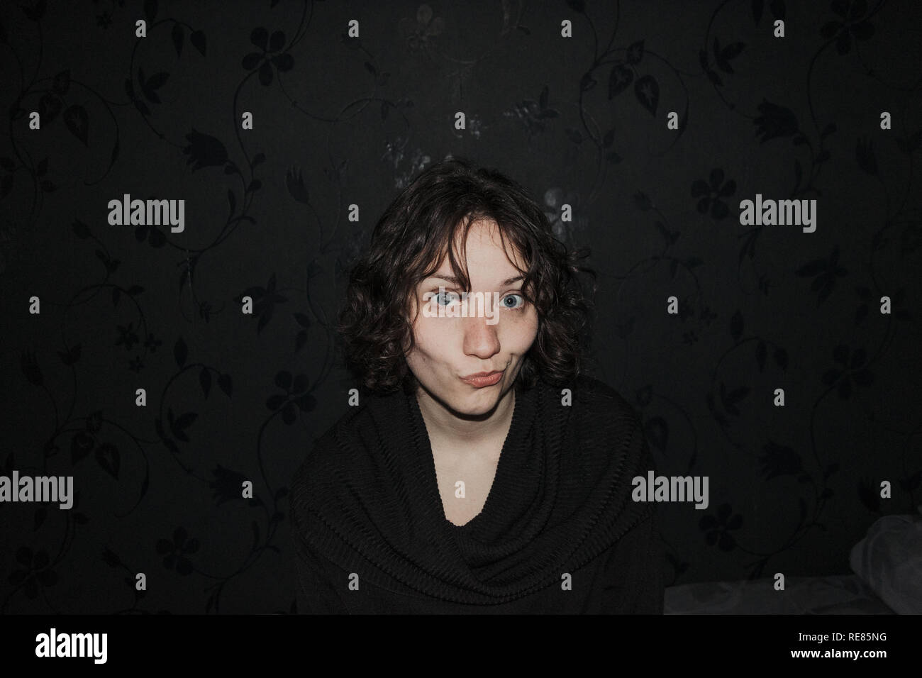 Blue-eyed girl facendo facce buffe guardando la telecamera Foto Stock