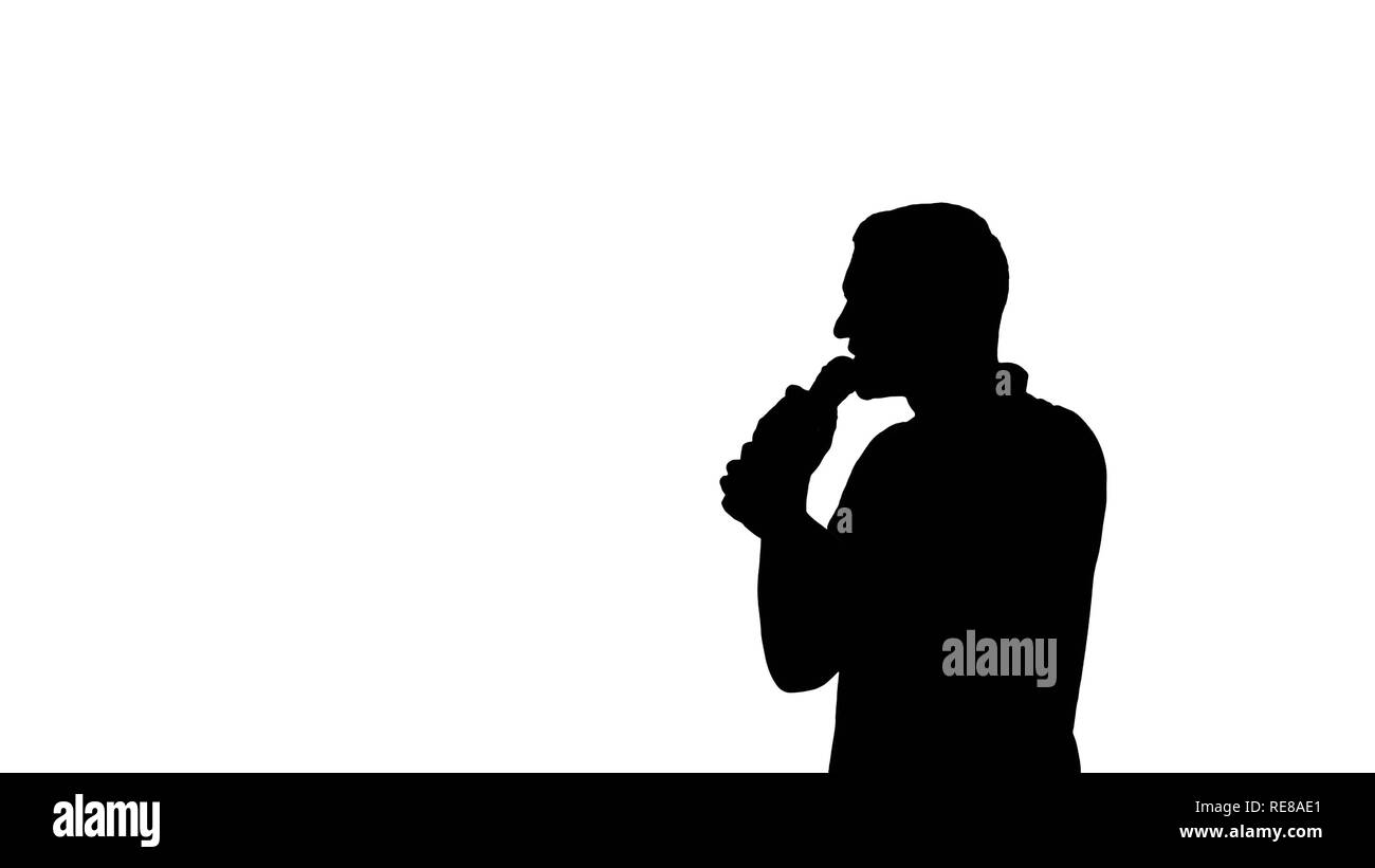 Irriconoscibile silhouette uomo parlando nel microfono - isolato su sfondo bianco. Comunicazione e parlare in pubblico nozione Foto Stock