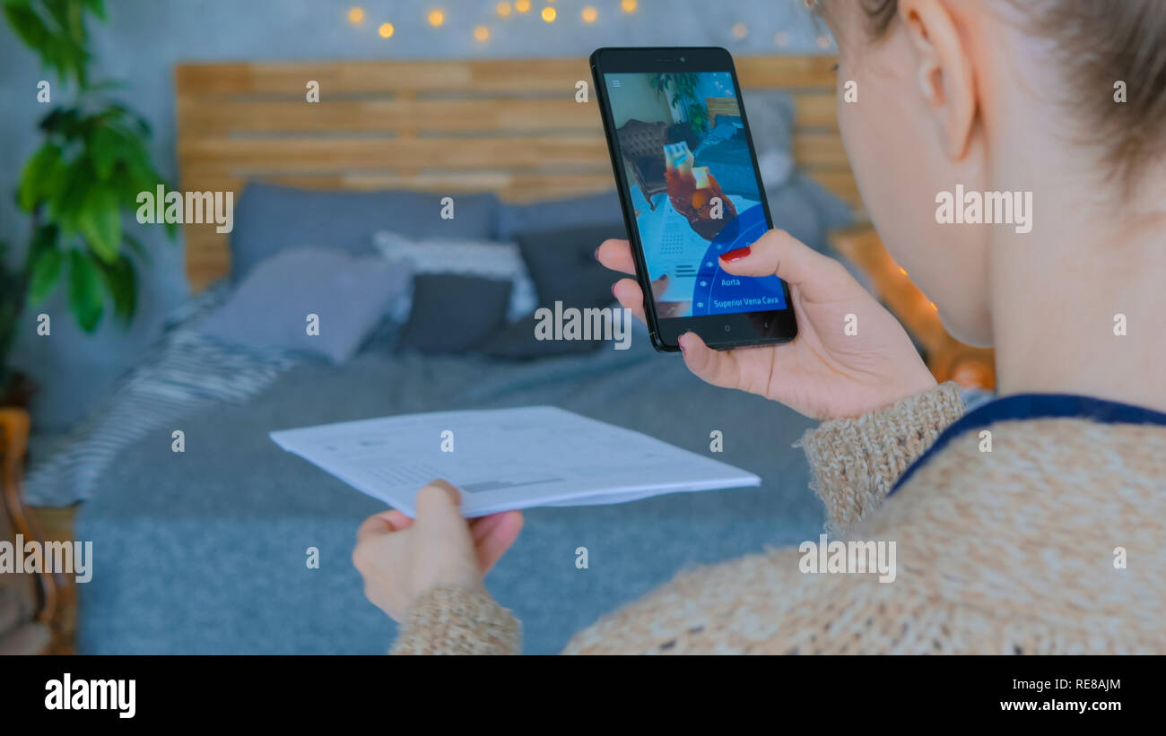 Mosca, Russia - 10 agosto 2018. Donna che utilizza smartphone con augmented reality app - modello anatomico del cuore umano. Futuro, medico e il concetto di tecnologia Foto Stock