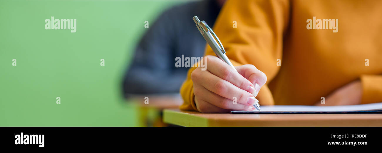 Gli studenti prendendo in esame in aula. La prova di educazione e il concetto di alfabetizzazione. Ritagliato shot, dettaglio a mano. Foto Stock