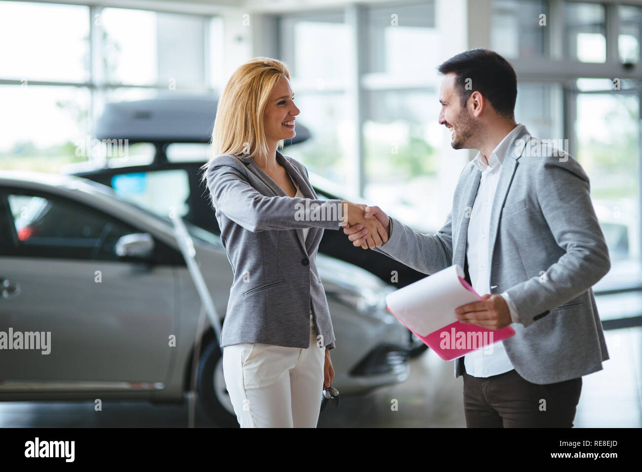 Addetto alle vendite professionali durante il lavoro con il cliente alla concessionaria auto. Foto Stock