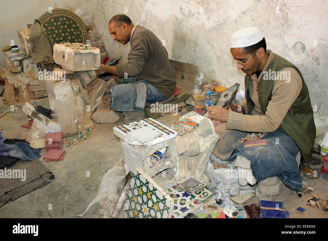 Artigiani rendendo piastrella Mosaico pezzi in ceramica co-operativa in Fez, in Marocco Foto Stock