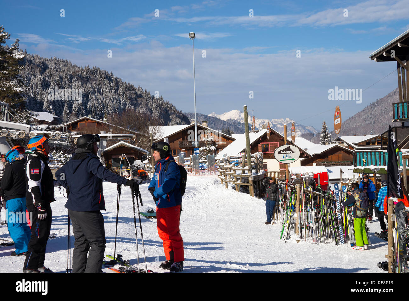 Gli sciatori rilassante al di fuori Le Pleney Bar, ristorante e giro in Gondola con montagne coperte di neve nelle Alpi francesi a Morzine Haute Savoie Francia Foto Stock